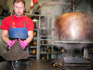 Adi Peermann setzt den Hut auf die Holzform auf, nachdem er den Rohling erst fuenf Minuten im Kessel bedampft hat. 