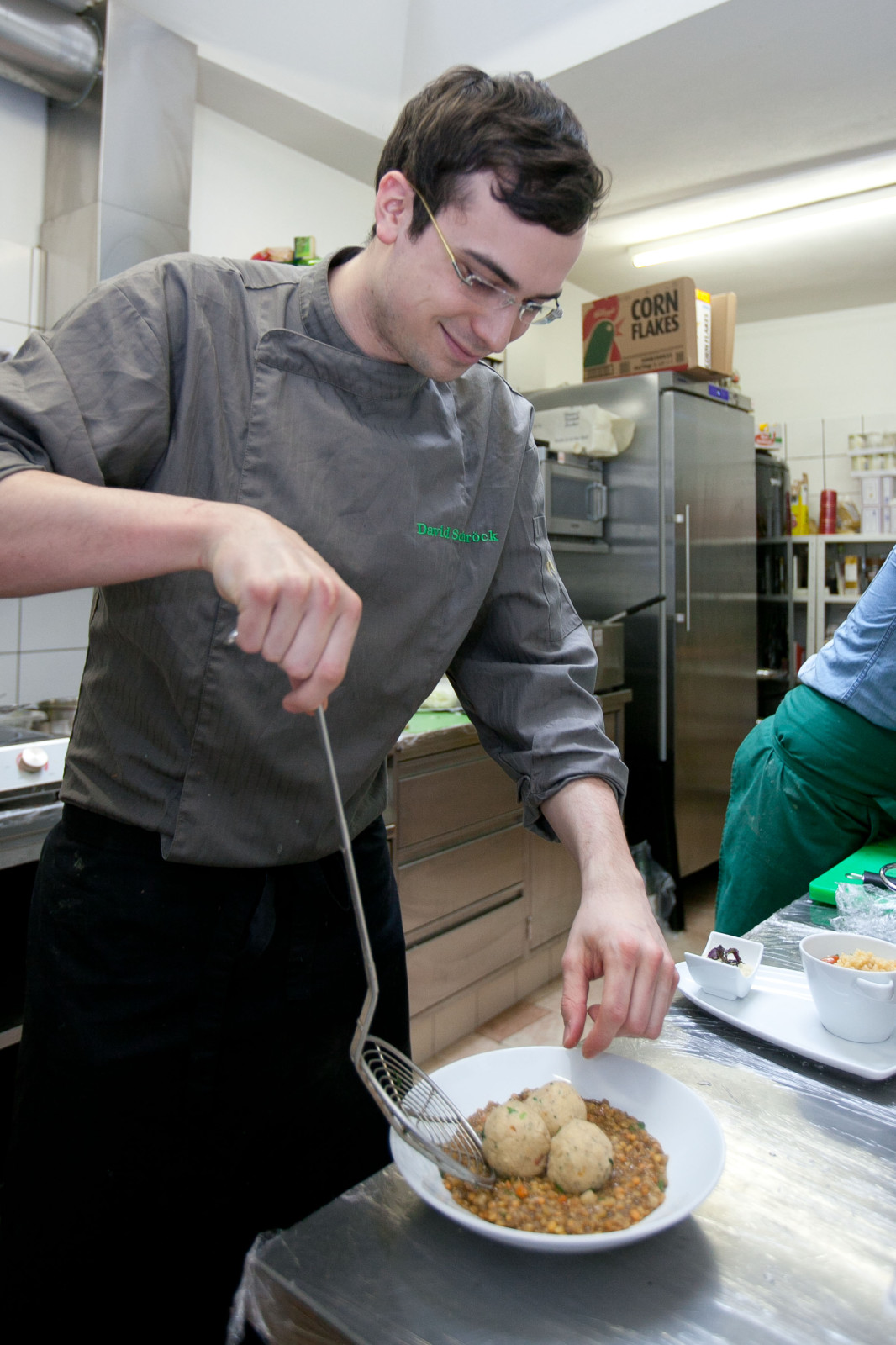 David Schröck garniert Basilikumknödel auf Balsamico-Linsen