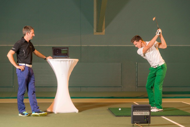 Abschlagtraining in der Abschlag-Trainingszone des neuen „GC Brandlhof Indoor Golf Performance-Center“ mit dem „TrackMan PRO IIIe“, einem Gerät zur High-Tech Golf-Leistungsdiagnostik, unter Anleitung von Markus Teubner (links), Golf-Experte von Systema Golf