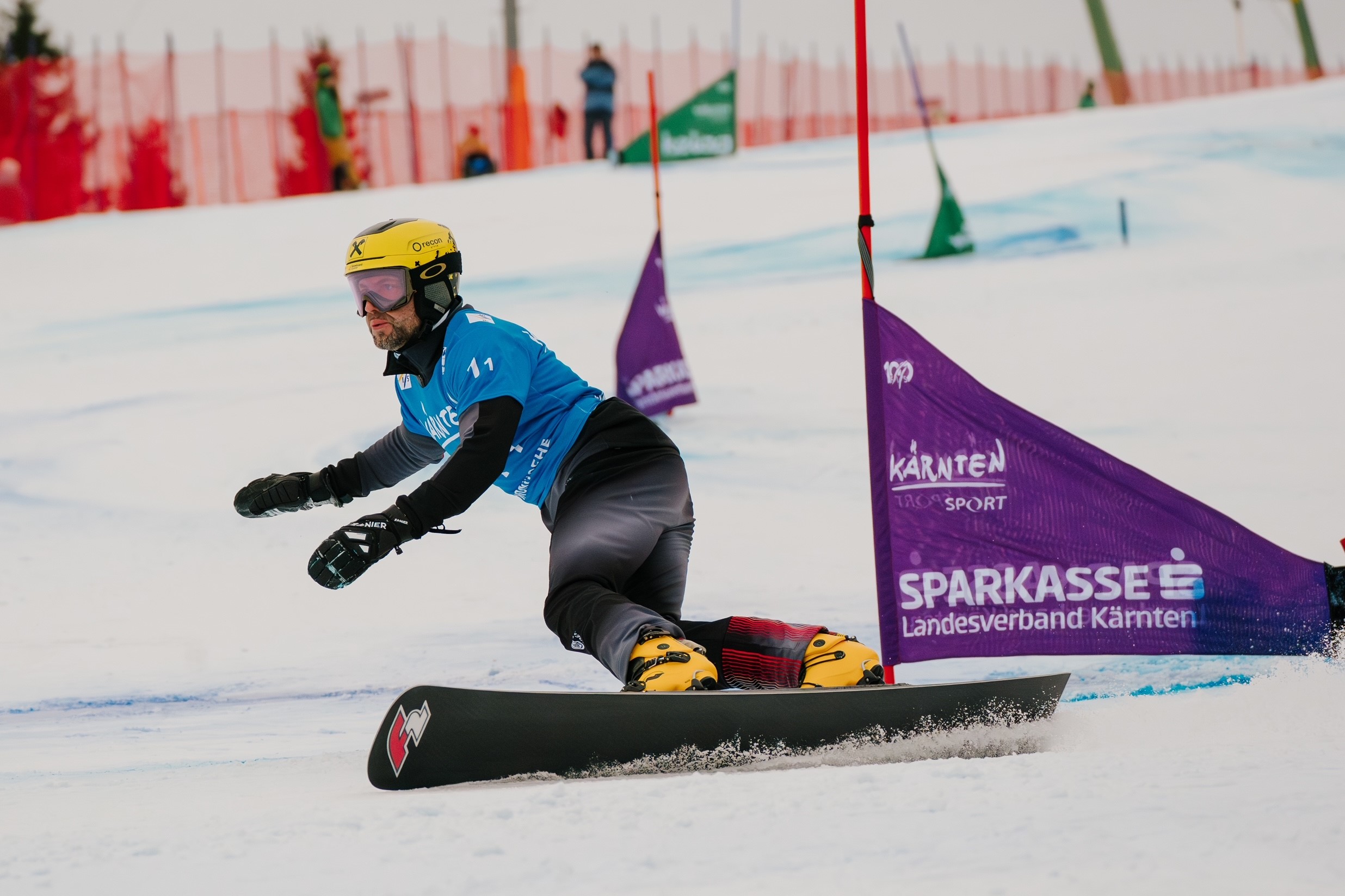 Der Snowboard-Weltmeister Andreas Prommegger aus dem SalzburgerLand rast auf einer verschneiten Piste um ein Tor herum.
