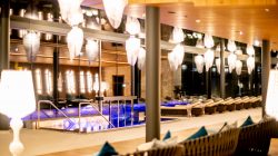 Der moderne Innenpool mit Liegestühlen, warmer Beleuchtung und großen Fenstern ist ein wahrer Wellness-Rückzugsort.