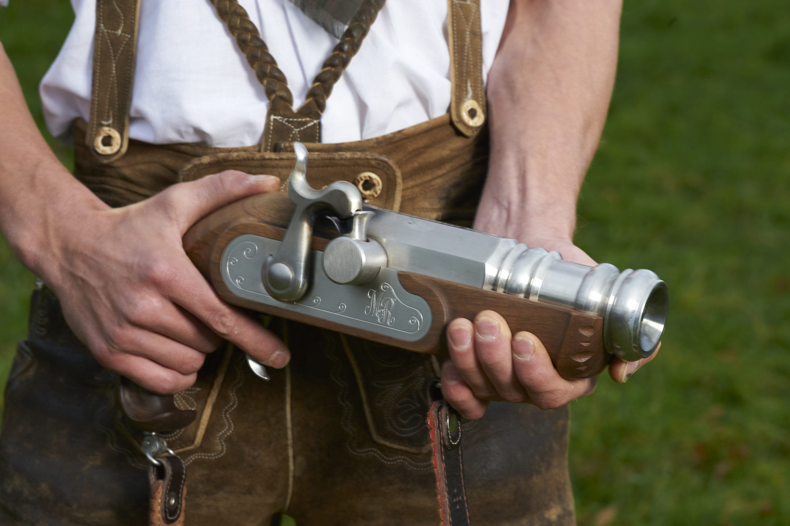 Eine Person in traditioneller österreichischer Kleidung hält einen dekorativen Böller, der lokales Kunsthandwerk zeigt.