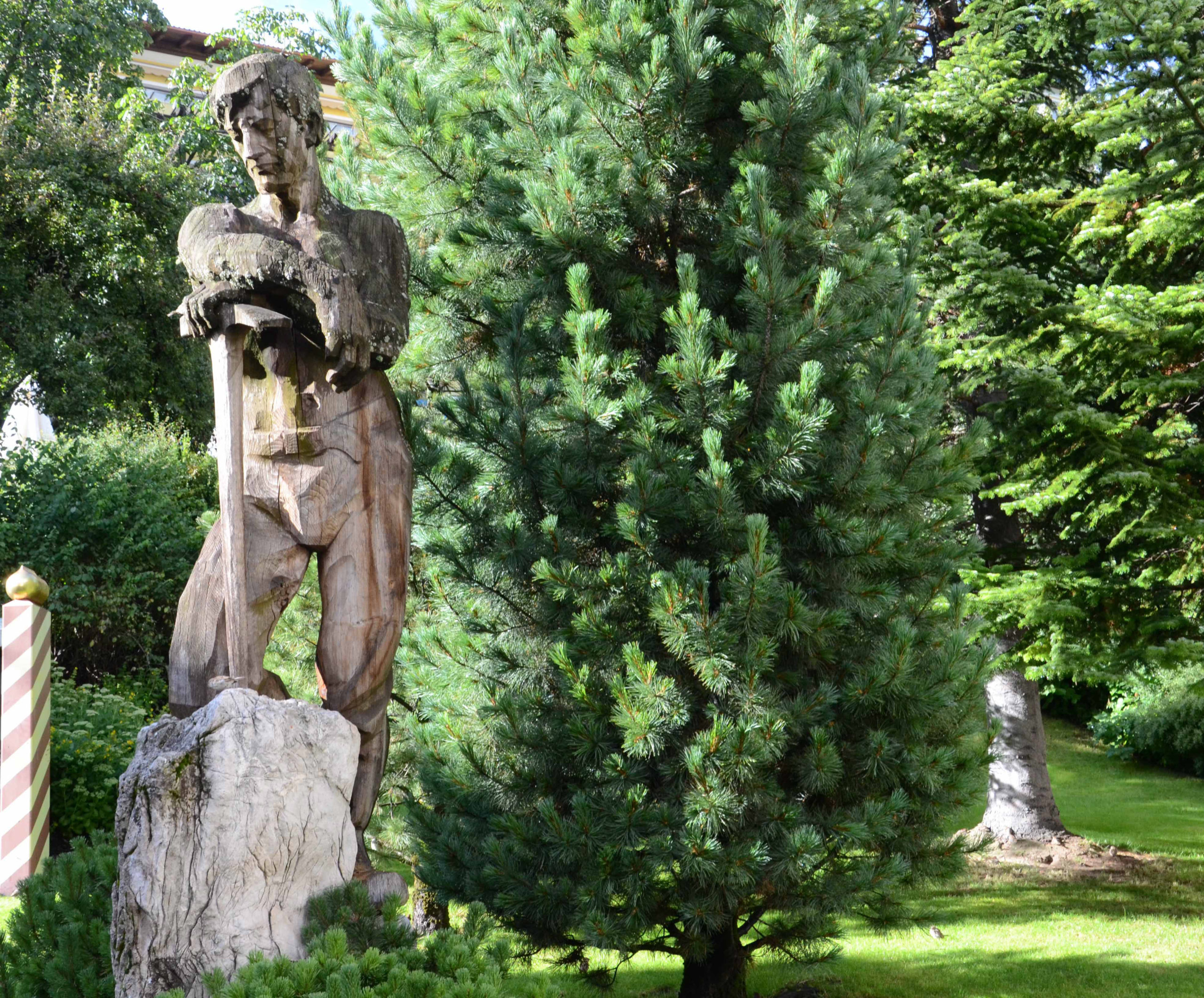 Statue in einem Garten mit Dolomitgestein und Zirbe