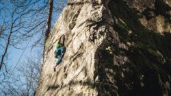 Eine Person erklimmt eine steile, felsige Klippe - Felsen klammen ist ein Paradies für Kletterer und Wanderer.