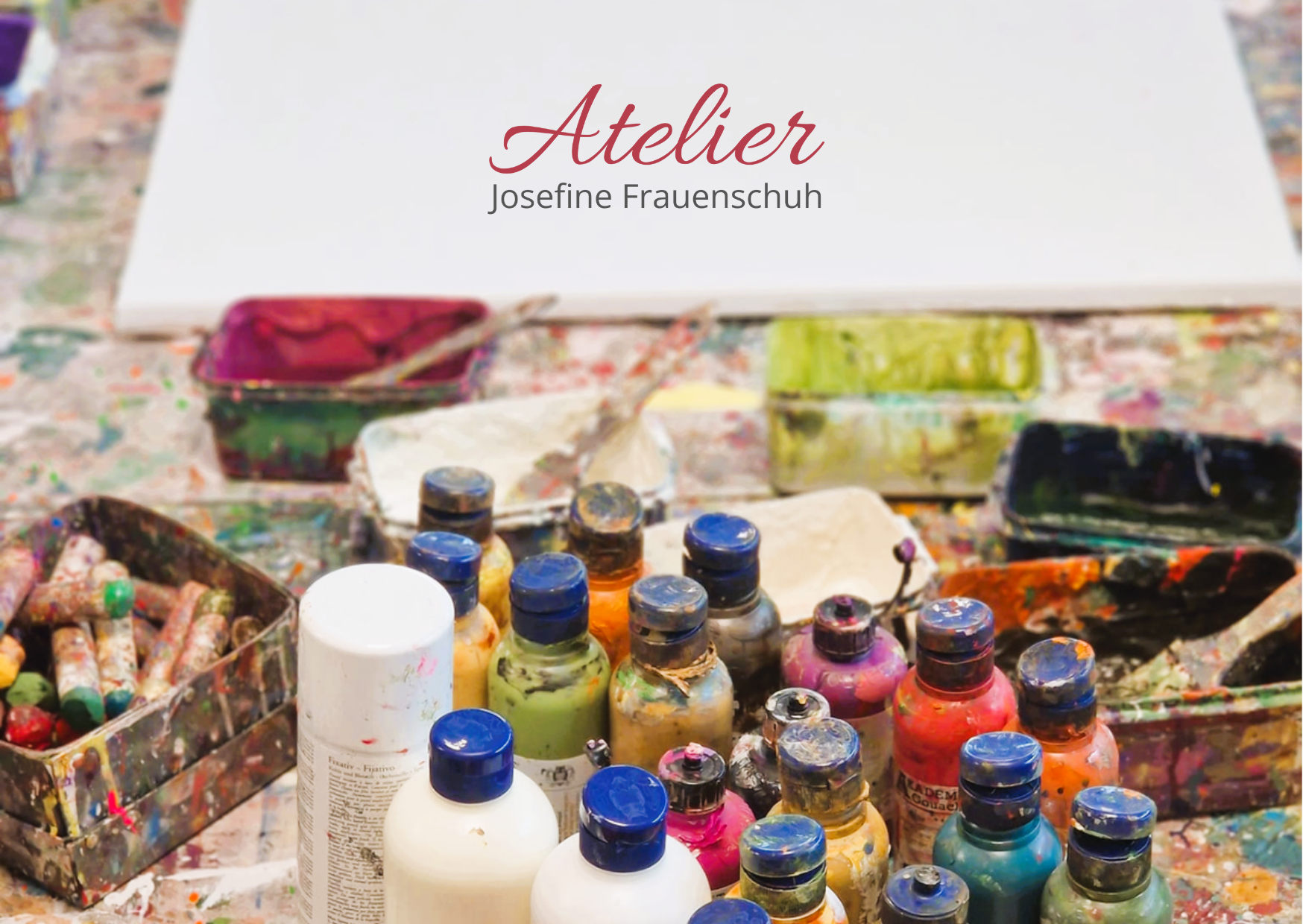 Farbflaschen, Pinsel und Paletten auf einem unordentlichen Ateliertisch, mit Atelier Josefine Frauenschuh im Text darüber.
