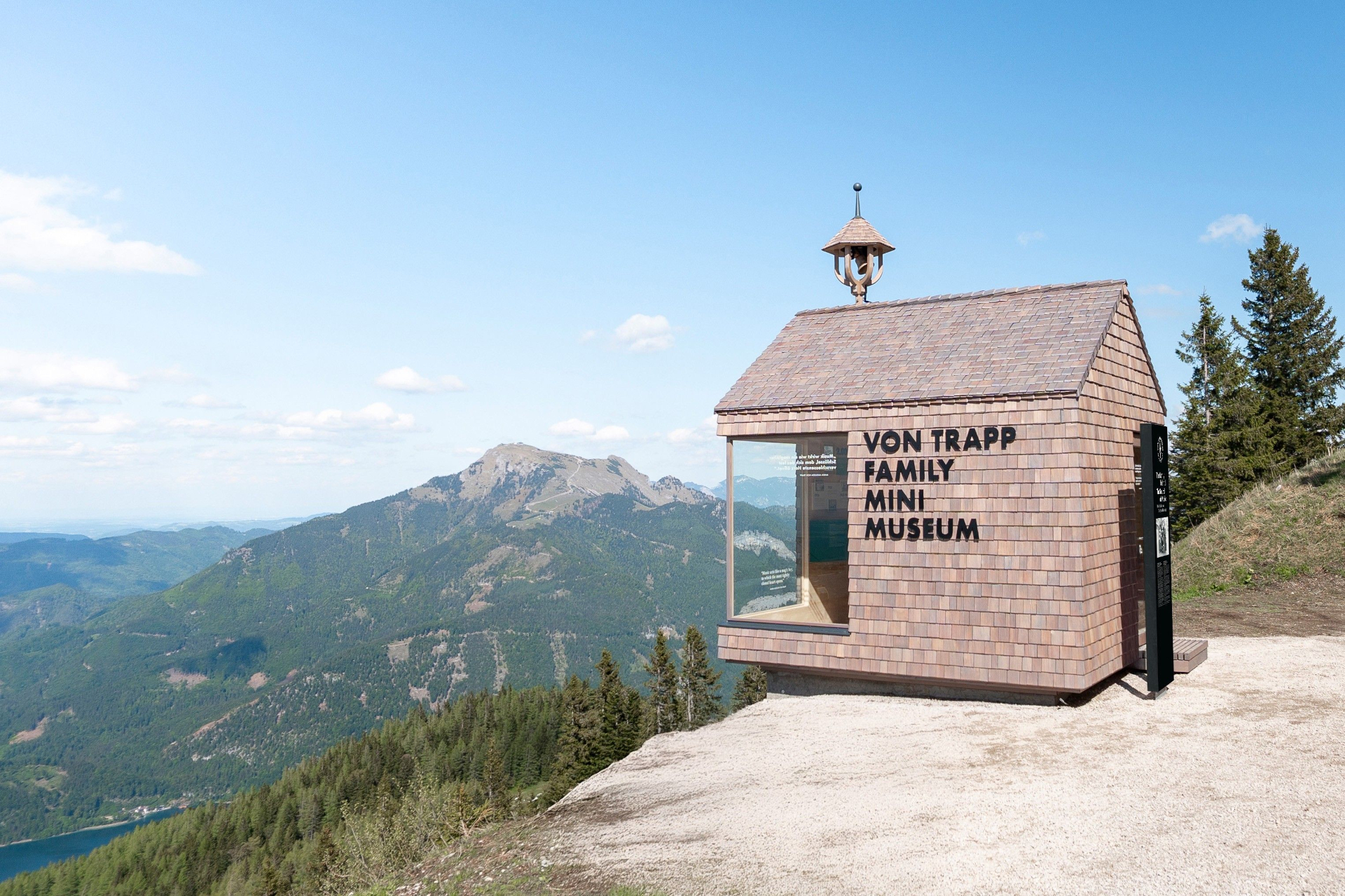 Das winzige, mit Schindeln bedeckte Mini-Museum der Familie Von Trapp liegt auf dem Zwölferhorn, mit Blick auf grüne Hügel und ferne Gipfel.