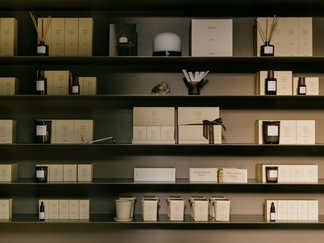 In den übersichtlichen Regalen stehen Manufaktur-Kerzen, Tiegel und Flaschen mit Hausdüften in neutralen Tönen.