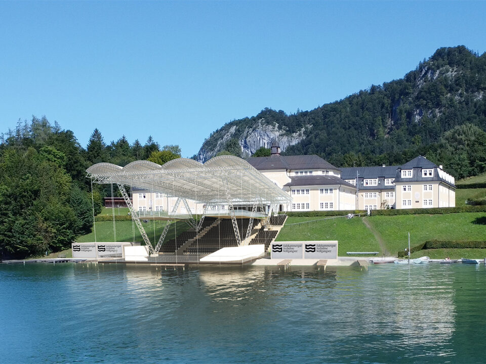 Ein moderner Pavillon am Wasser mit einem geschwungenen Dach erinnert an Wolf-das Mystische vor Hügeln unter blauem Himmel.