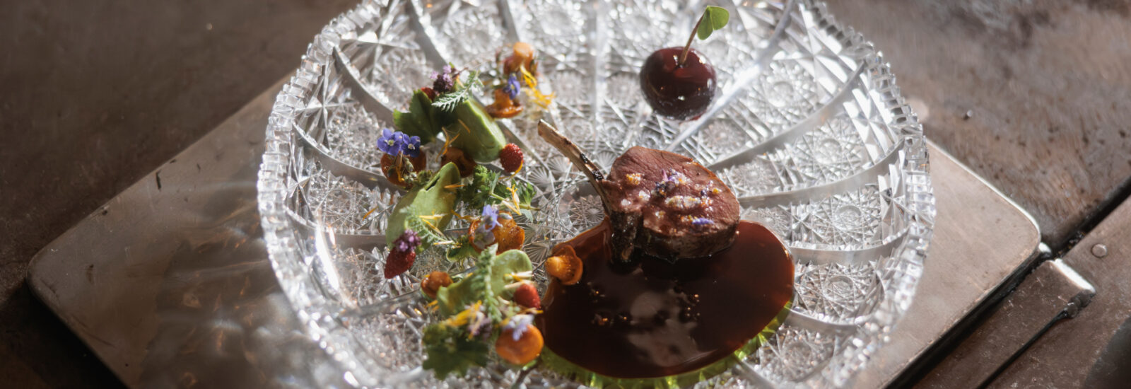 in Gedicht für alle Sinne. Der rosa gebratene Rehrücken wird mit Kräuterpüree, Wildkräuteröl, Fleischsauce, Eierschwammerln und der Pasteten-Kirsche angerichtet. ©Schwaigerlehen, Florian Voggeneder