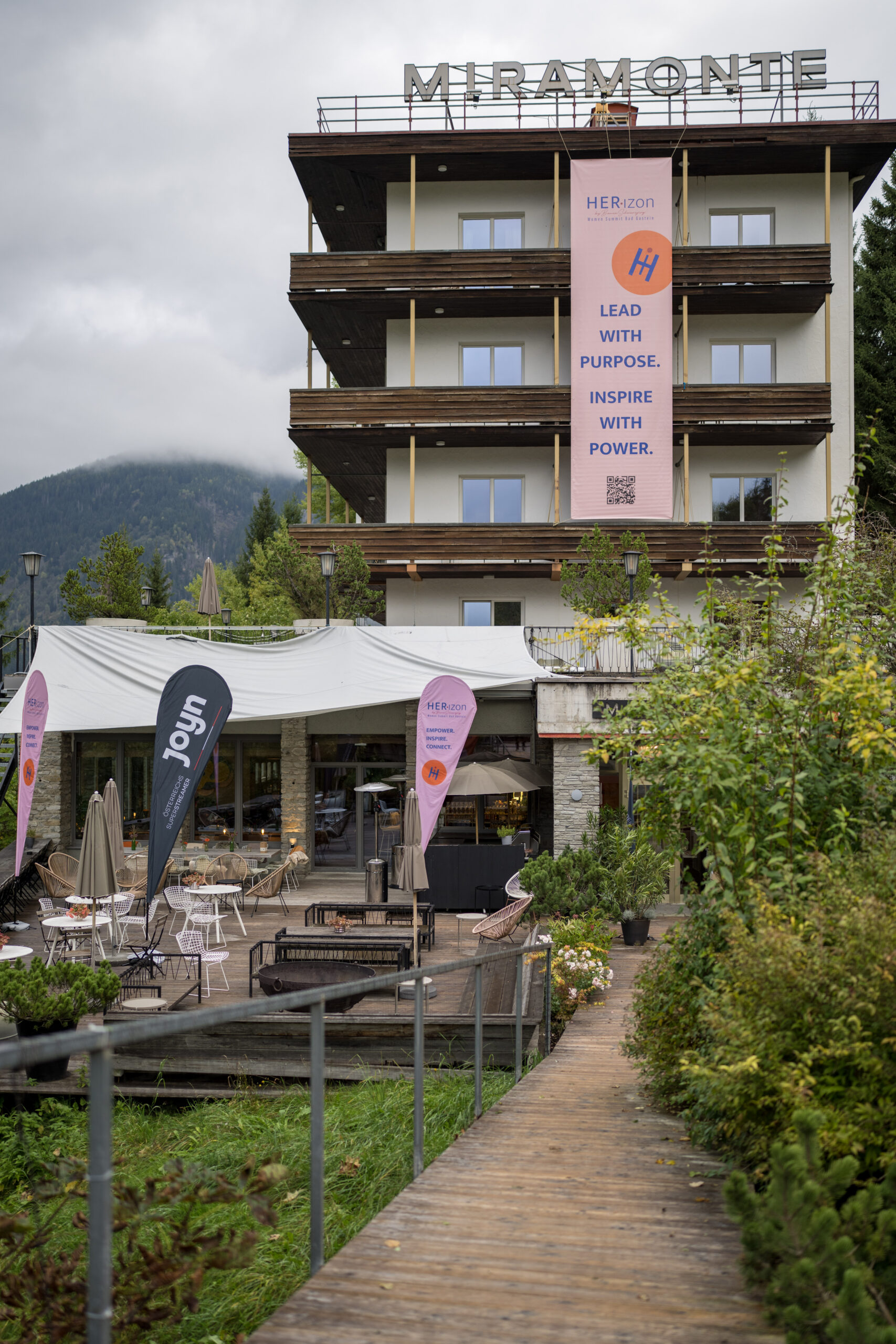 Das Hotel Miramonte mit Bannern mit den Aufschriften &bdquo;Lead with Purpose. Inspire with Power.&ldquo; und einem Au&szlig;enbereich.