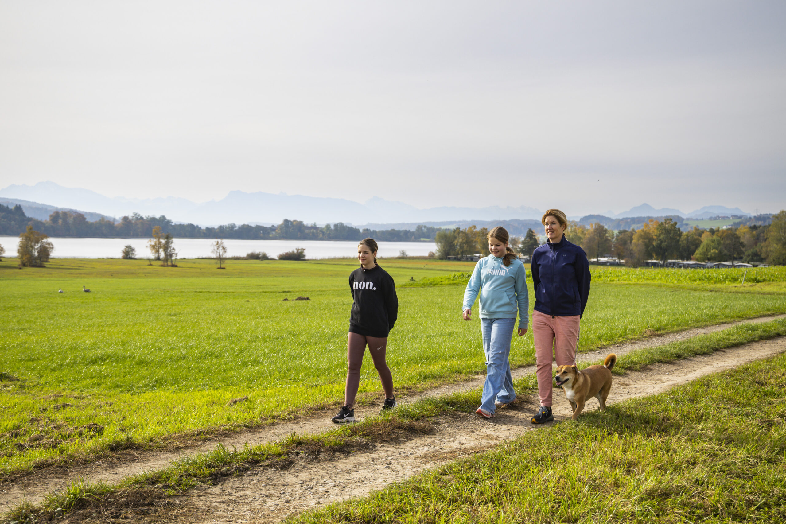 Drei Menschen und ein Hund wandern auf dem Grabensee-Weg, umgeben von unberührter Natur und faszinierenden Landschaften.