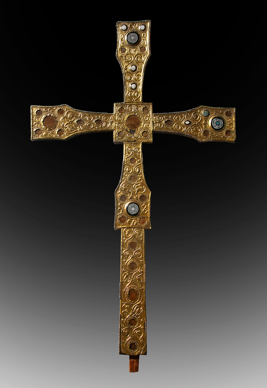 Gold- und juwelenbesetztes mittelalterliches Kreuz mit verschlungenen Mustern auf einem dunklen Hintergrund mit Farbverlauf.