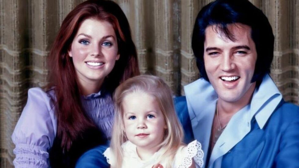 Ein lächelnder Mann und eine lächelnde Frau mit einem jungen Mädchen zwischen ihnen posieren für ein Porträt vor einem Vorhang.