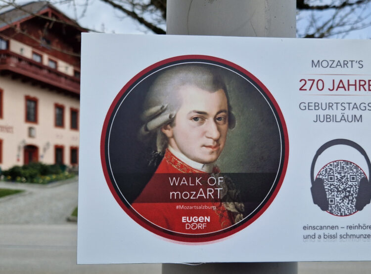 Plakat an einer Stange mit Mozarts Porträt, mit Text zu seinem 270. Geburtstag und einem QR-Code.