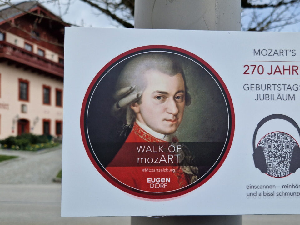 Plakat an einer Stange mit Mozarts Porträt, mit Text zu seinem 270. Geburtstag und einem QR-Code.
