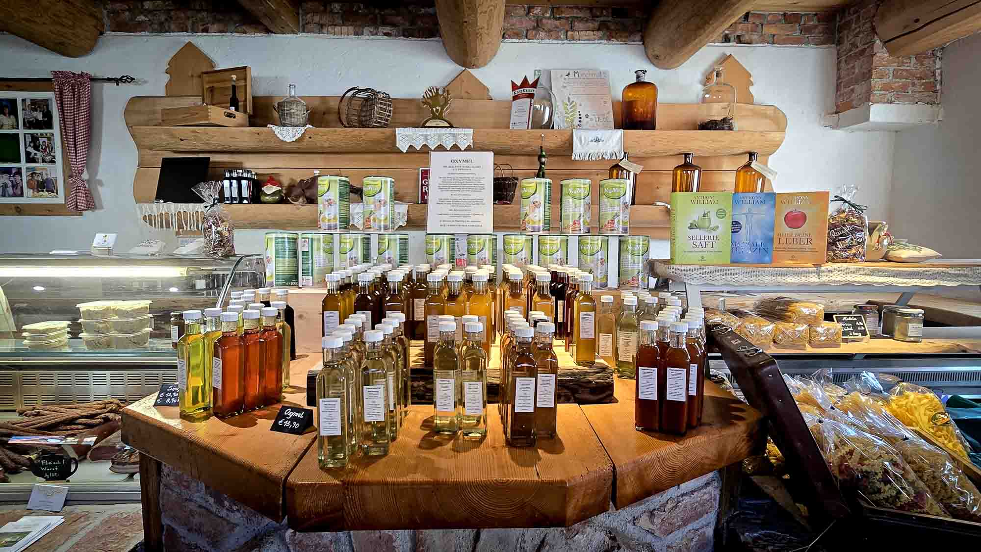 Hofladen in Kathis Blumencafé auf einer rustikalen Holztheke, dahinter Regale mit Waren. © Melanie Deisl