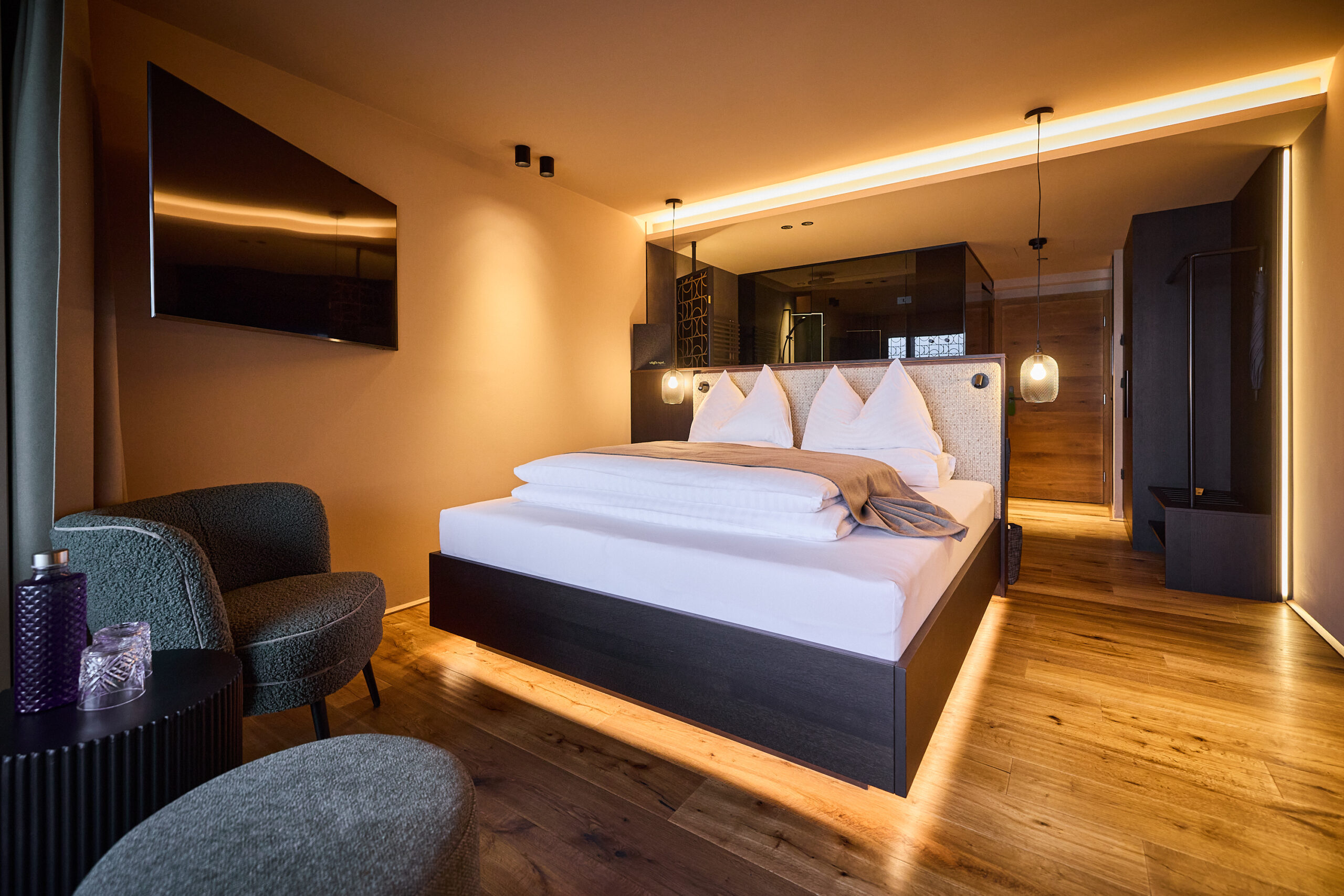 Modernes Hotelzimmer mit Holzböden und warmer Stimmungsbeleuchtung © Vogl's Nest
