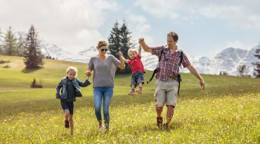 Familie auf der blühenden Almwiese.