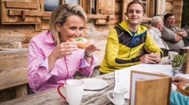 © SalzburgerLand Tourismus, Michael Größinger, Alexandra Meissnitzer beim Krapfenessen auf der Gainschniggalm